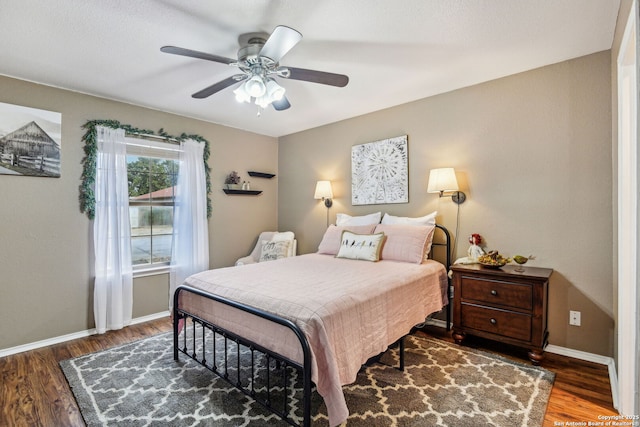 bedroom with ceiling fan, baseboards, and wood finished floors