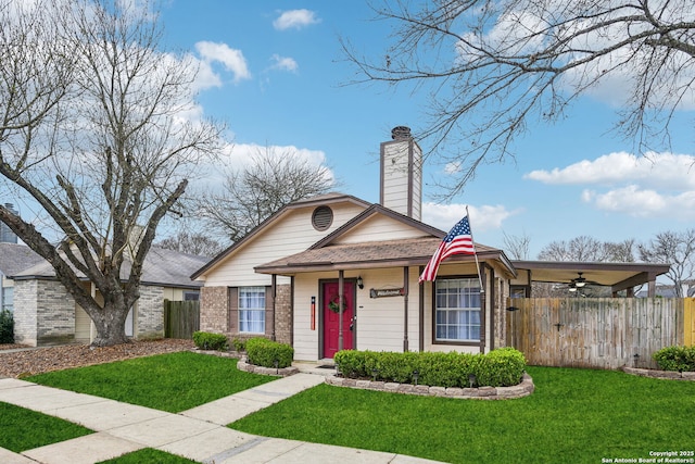 view of front of home with a front lawn, fence, brick siding, and a chimney