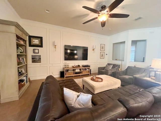 living area featuring crown molding, a decorative wall, and visible vents