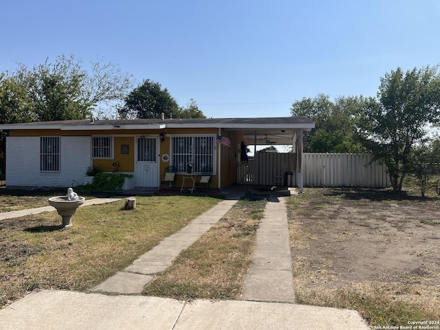 view of front of property featuring an attached carport, a front yard, a gate, fence, and driveway