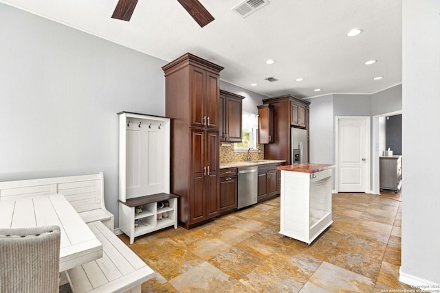 kitchen with a kitchen island, visible vents, stainless steel appliances, and decorative backsplash