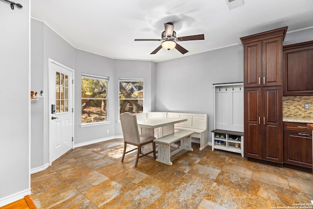 dining room featuring stone finish flooring, visible vents, baseboards, and ceiling fan