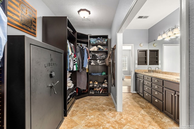 walk in closet with visible vents and a sink