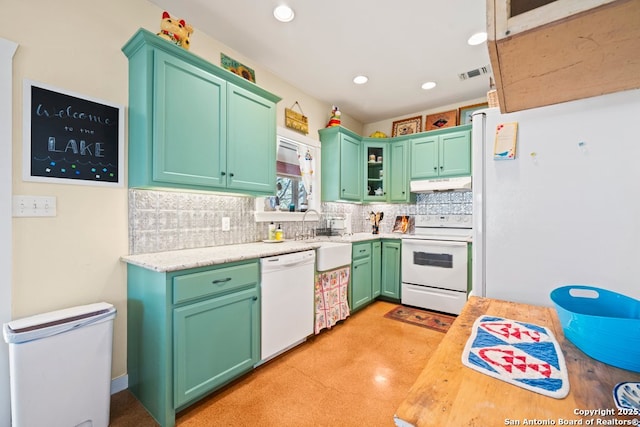 kitchen featuring white appliances, a sink, decorative backsplash, light countertops, and under cabinet range hood