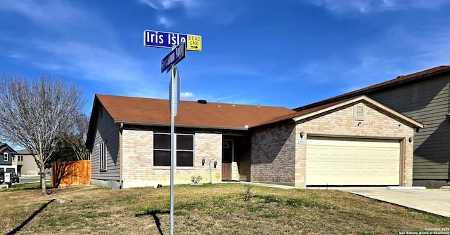 ranch-style house featuring driveway, an attached garage, and a front yard