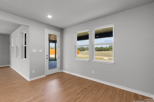 unfurnished room featuring light wood finished floors and baseboards