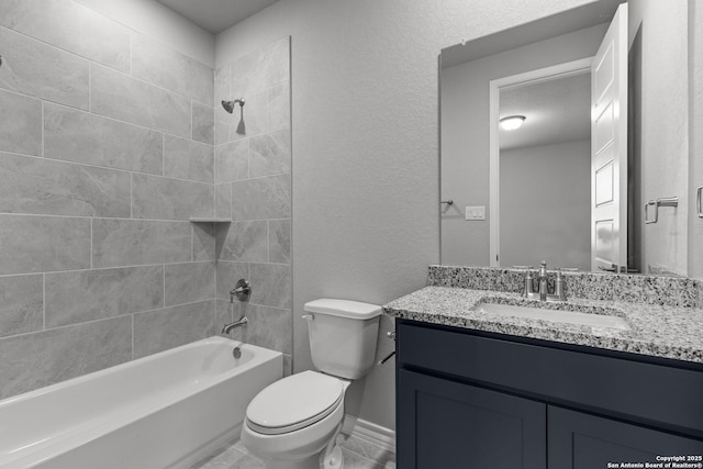 full bath featuring baseboards, washtub / shower combination, toilet, a textured wall, and vanity