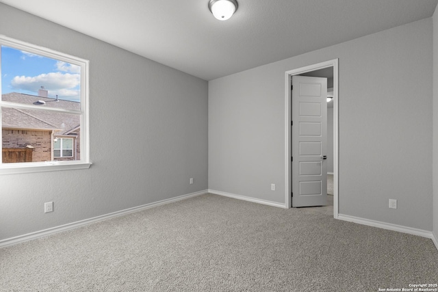 carpeted empty room with baseboards