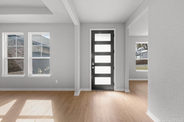 foyer with baseboards and light wood finished floors