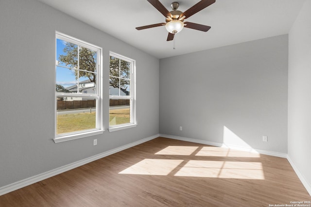 unfurnished room with a ceiling fan, baseboards, and wood finished floors