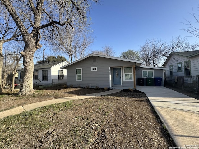 view of front facade featuring driveway and fence