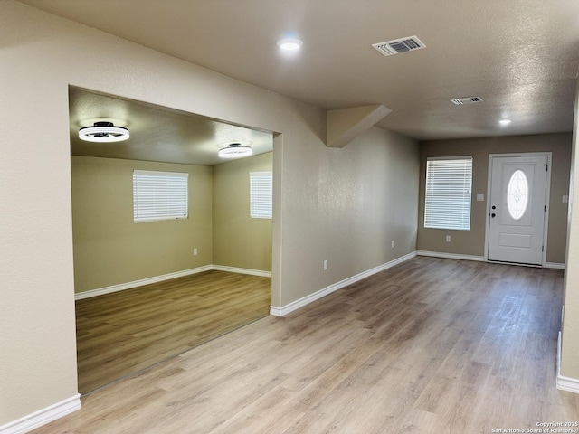 foyer with visible vents, baseboards, and wood finished floors