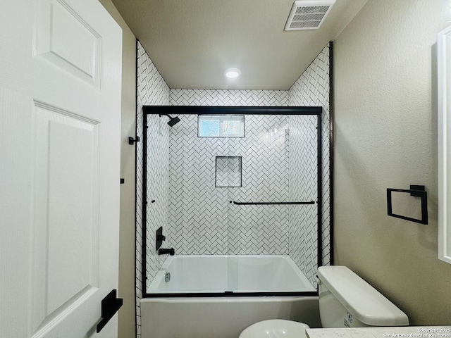 full bathroom with toilet, a textured wall, visible vents, and enclosed tub / shower combo