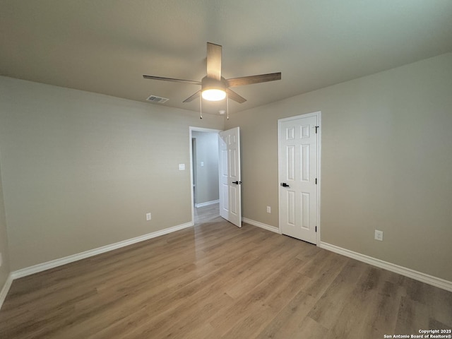 unfurnished bedroom with ceiling fan, visible vents, baseboards, and wood finished floors