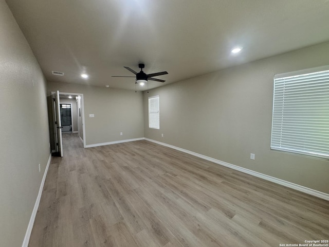 spare room featuring visible vents, light wood-style flooring, a ceiling fan, recessed lighting, and baseboards