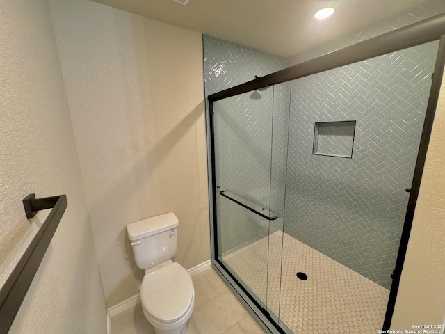 full bath with tile patterned floors, toilet, and a shower stall