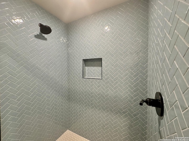 interior details with a tile shower