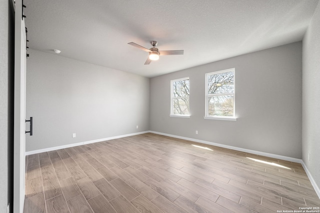 spare room with a ceiling fan, wood finished floors, and baseboards