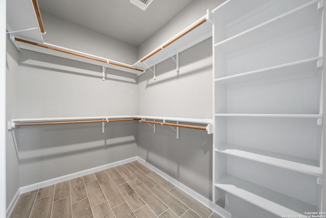 spacious closet featuring visible vents and wood finish floors