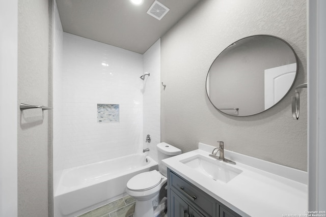 bathroom featuring visible vents, toilet, bathing tub / shower combination, a textured wall, and vanity