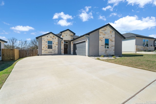 view of front of home featuring a front lawn, stone siding, fence, concrete driveway, and an attached garage