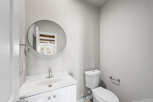 bathroom with vanity, toilet, and baseboards