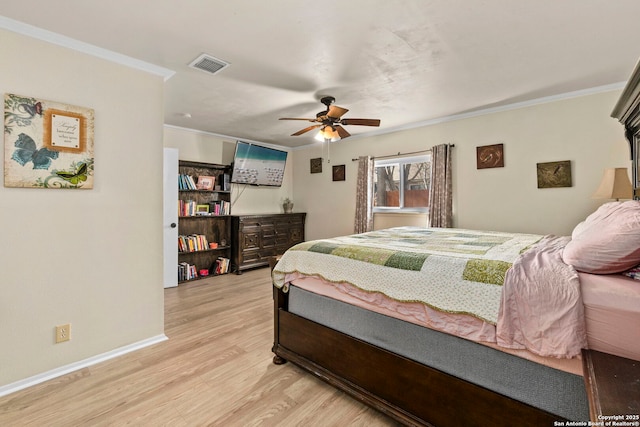 bedroom featuring crown molding, light wood-style flooring, baseboards, and visible vents