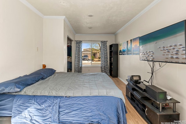 bedroom featuring wood finished floors, baseboards, and ornamental molding