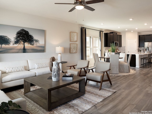 living room featuring recessed lighting, light wood-style flooring, and ceiling fan