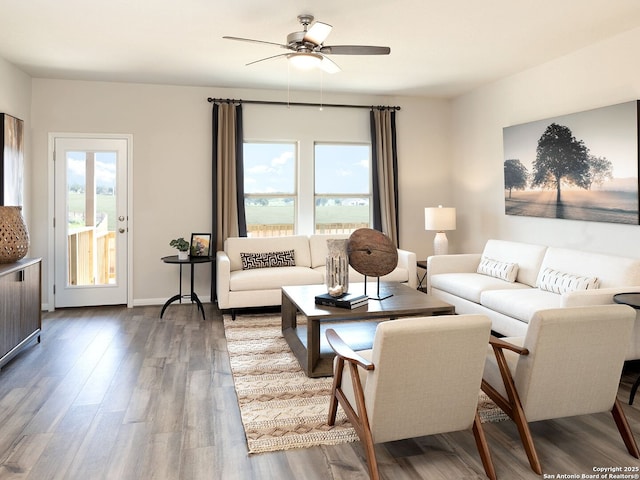 living area featuring baseboards, wood finished floors, and a ceiling fan