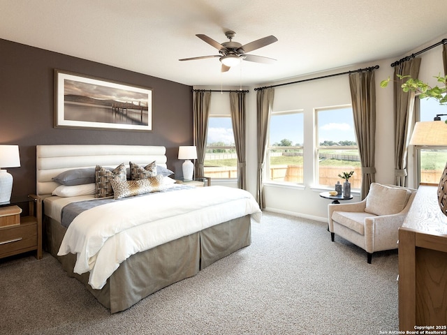 carpeted bedroom featuring baseboards and ceiling fan