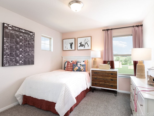 bedroom with light carpet, multiple windows, and baseboards