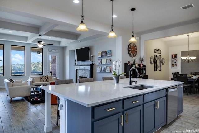 kitchen featuring visible vents, a sink, open floor plan, a fireplace, and dishwasher