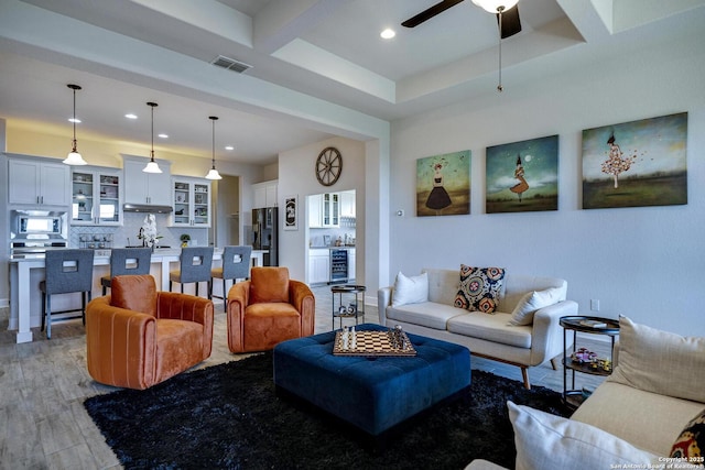 living room with light wood-type flooring, visible vents, beverage cooler, a ceiling fan, and recessed lighting