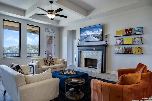 living area featuring beamed ceiling, baseboards, coffered ceiling, and a fireplace