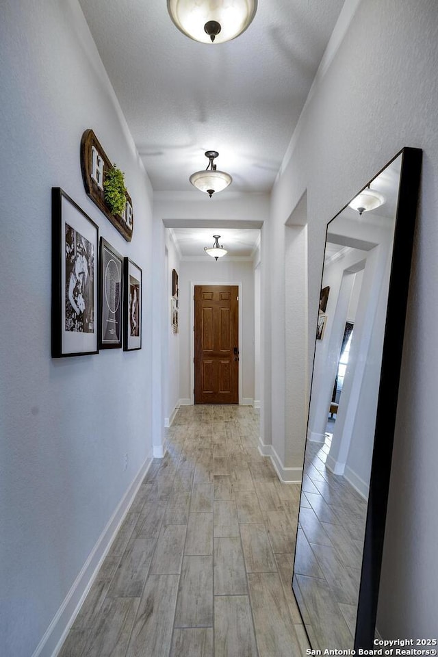 corridor with baseboards and ornamental molding