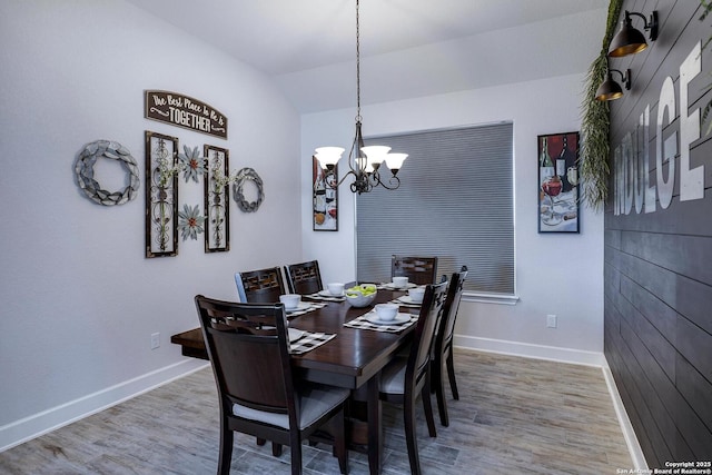 dining space with wood finished floors, baseboards, and a chandelier