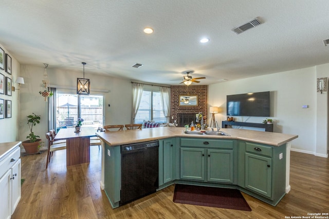 kitchen featuring visible vents, green cabinets, a sink, light countertops, and dishwasher