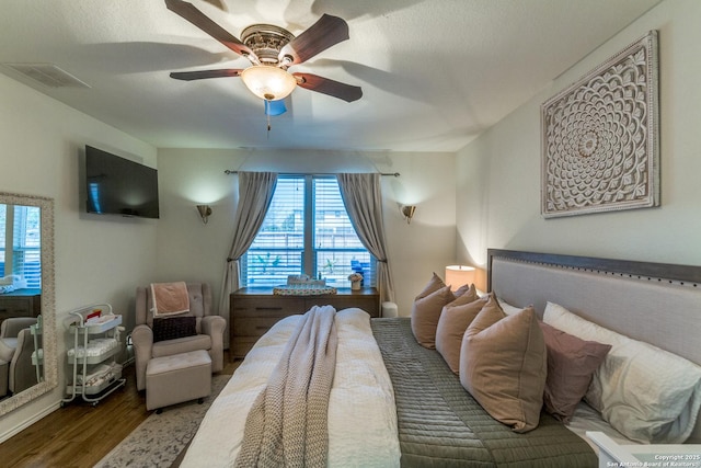 bedroom featuring ceiling fan, visible vents, and wood finished floors