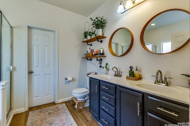 full bath featuring double vanity, toilet, wood finished floors, and a sink