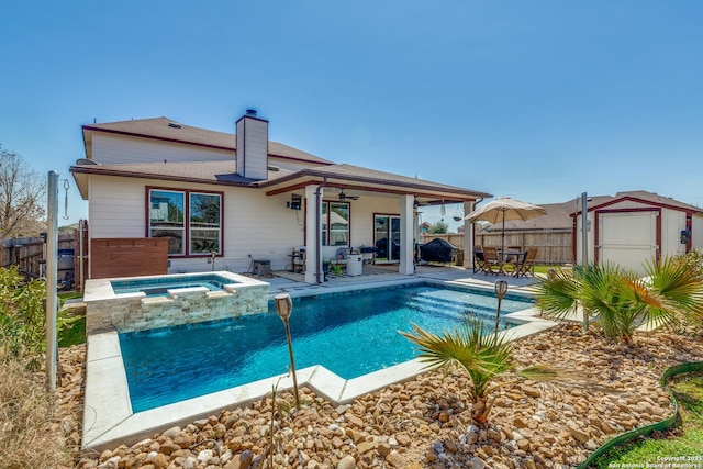 view of pool with a storage unit, a fenced backyard, an outdoor structure, ceiling fan, and a patio area