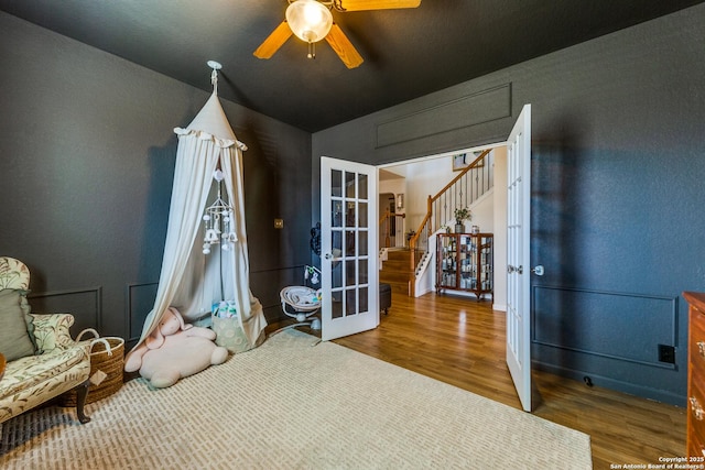 interior space with wood finished floors, french doors, and ceiling fan