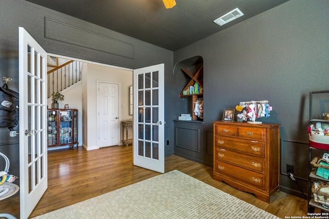 bedroom with visible vents, french doors, and wood finished floors