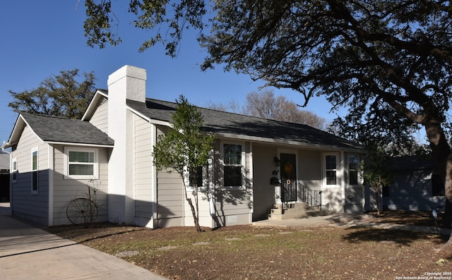 single story home featuring roof with shingles and a chimney