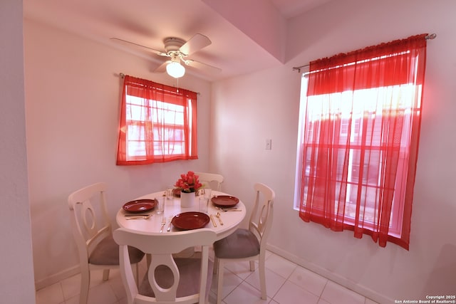 tiled dining area featuring baseboards and ceiling fan