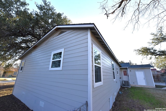 view of side of property with cooling unit and crawl space