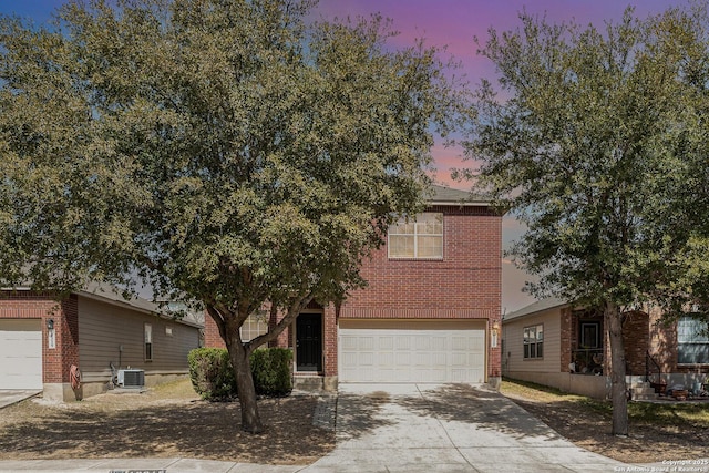 view of front facade with concrete driveway, central air condition unit, a garage, and brick siding