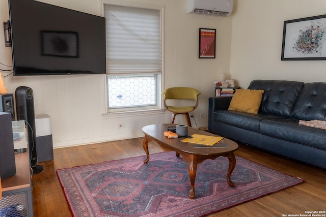 living room with a wall mounted air conditioner and wood-type flooring