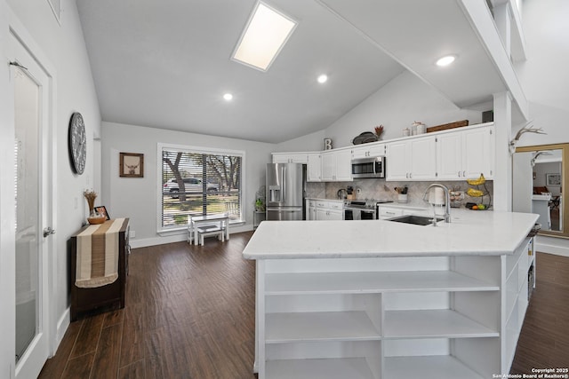 kitchen with open shelves, a sink, appliances with stainless steel finishes, dark wood-style flooring, and vaulted ceiling