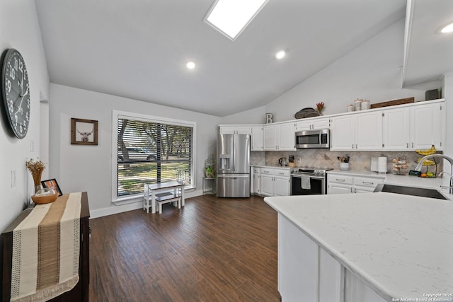 kitchen with a sink, dark wood-style floors, white cabinetry, stainless steel appliances, and decorative backsplash